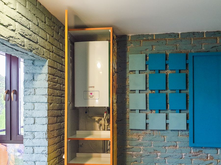 Wall-mounted tankless water heater in a modern cabinet installation